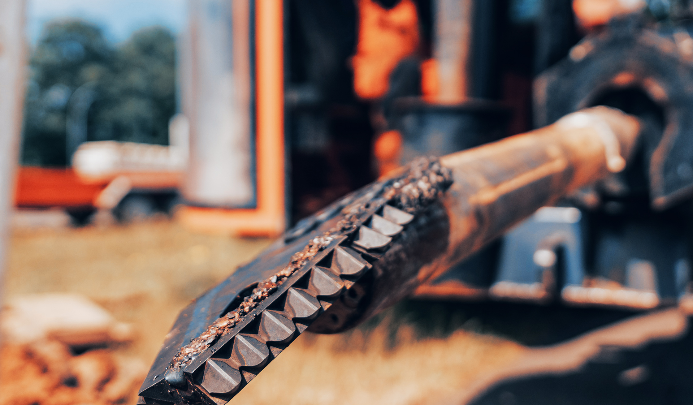 Nahaufnahme eines schweren Bohrkopfes, der mit Erde bedeckt ist.