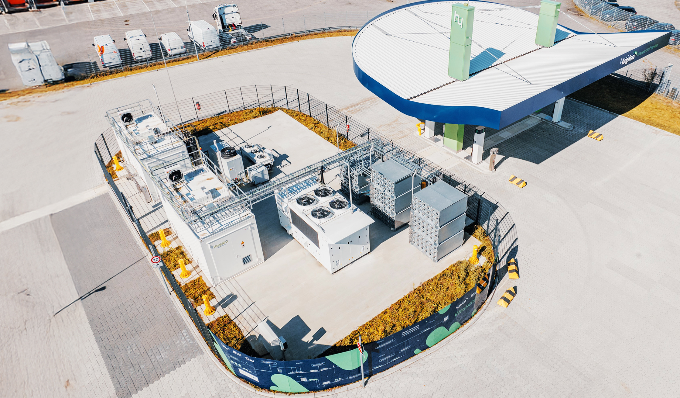 Referenz Hypion Wasserstofftankstelle Neumünster: Luftaufnahme einer modernen Wasserstoff-Tankstelle mit Überdachung, technischen Anlagen und angrenzenden Gebäuden.