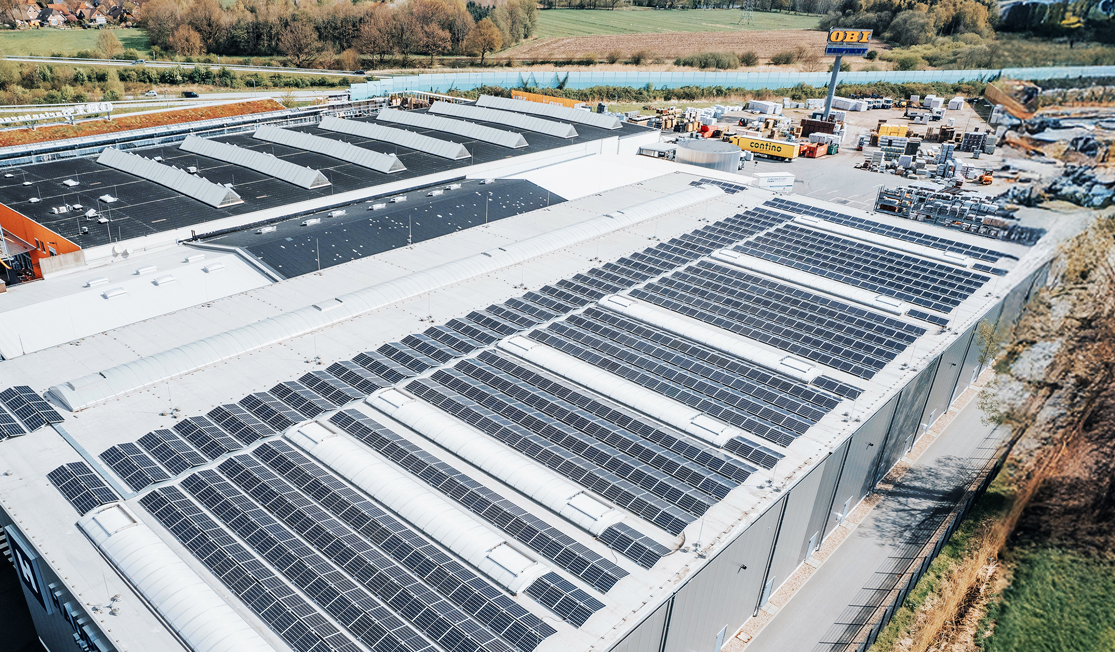 Luftaufnahme einer großen Dachfläche mit zahlreichen installierten Solarmodulen.